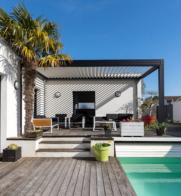 pergolas noire sur maison aux murs blancs avec piscine en bord de terrasse